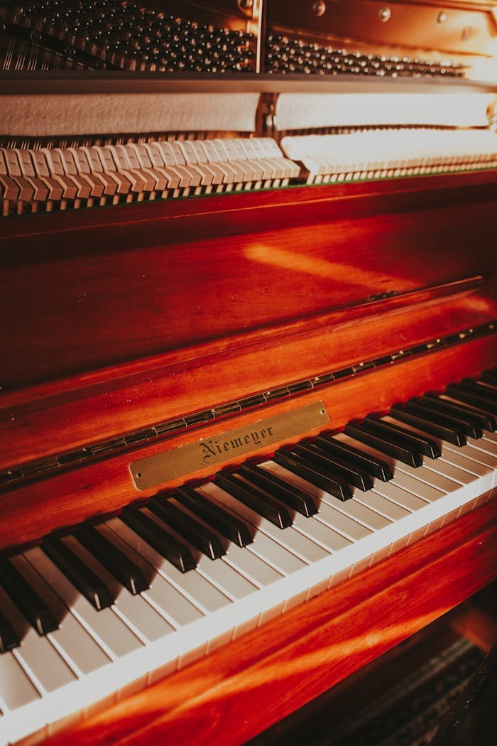 Detailed view of a vintage upright piano keyboard with a classic design and warm tones.